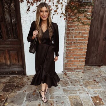 Corrine wearing black faux wrap dress