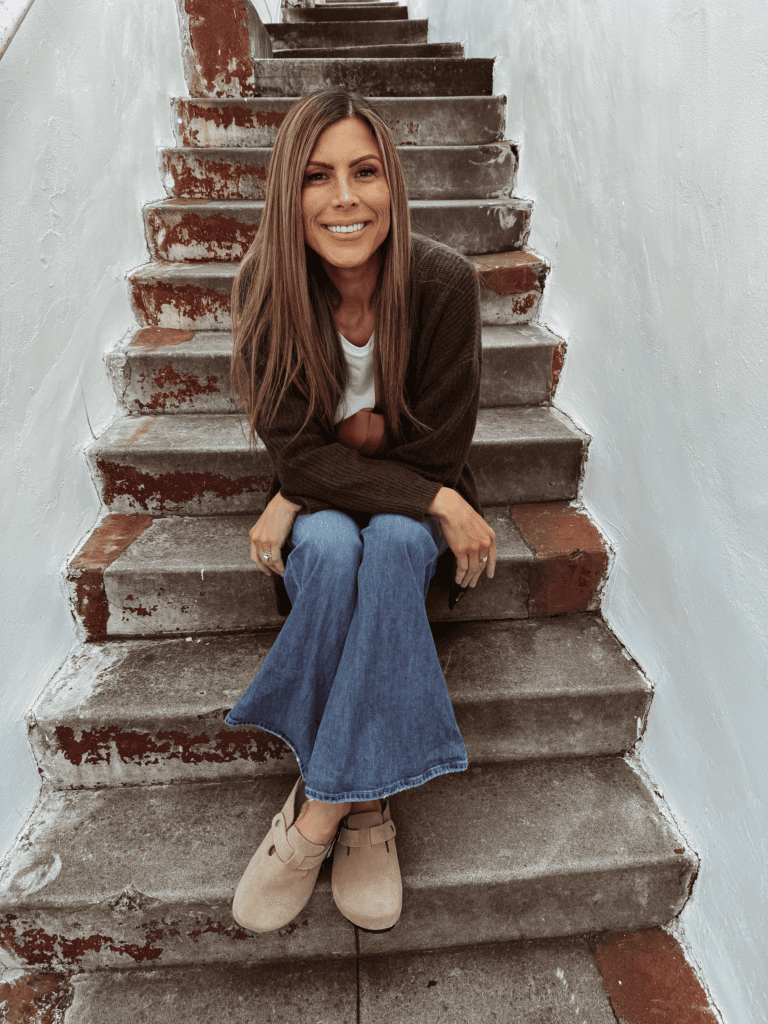 Corrine sitting on the stairs wearing Birkenstock dupe